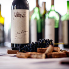 Load image into Gallery viewer, Jim-Barry-The-Armagh-Shiraz wine bottle with grapes on a wooden board, with blurred wine bottles in the background.