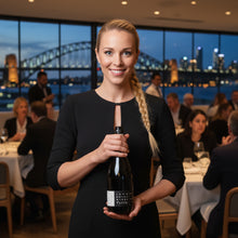 Load image into Gallery viewer, Woman holding a bottle of John-Duval-Entity-Shiraz wine in a restaurant with a cityscape view