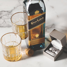 Load image into Gallery viewer, Johnnie Walker Blue Label whisky bottle with two glasses and a ring box on a marble surface