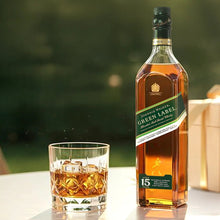 Load image into Gallery viewer, Johnnie Walker Green Label bottle with a glass of whiskey on a blurred green background