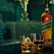Load image into Gallery viewer, Johnnie Walker Green Label whisky bottle with two glasses on a table in a dimly lit room.