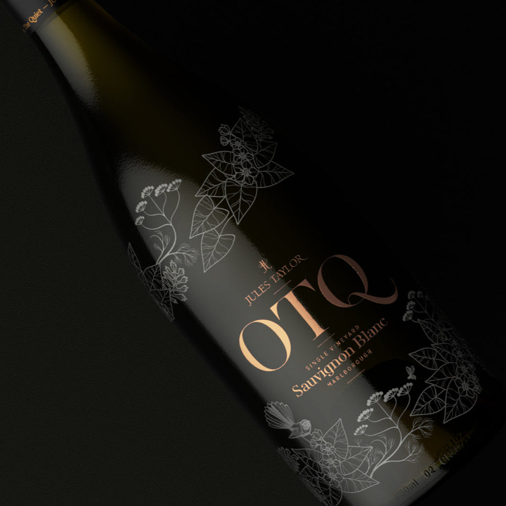 Wine bottle with 'OTQ' label on a dark background