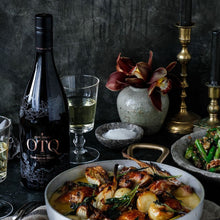 Load image into Gallery viewer, Dinner setup with OTQ wine, roasted dish, and candles on a dark surface