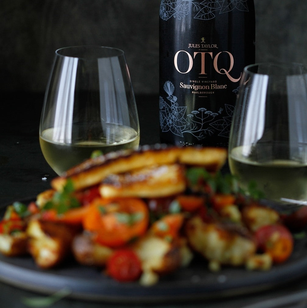Load image into Gallery viewer, A bottle of white wine and glasses with a dish of food on a dark background