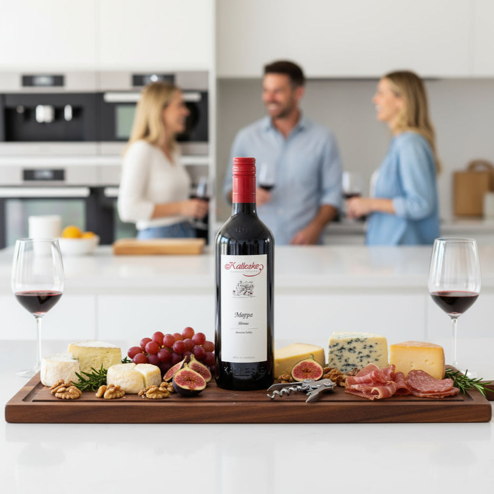 Kalleske-Moppa-Shiraz bottle on a charcuterie board with people in the background