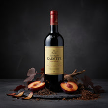 Load image into Gallery viewer, Bottle of Kanonkop Kadette Pinotage wine with plums on a dark background