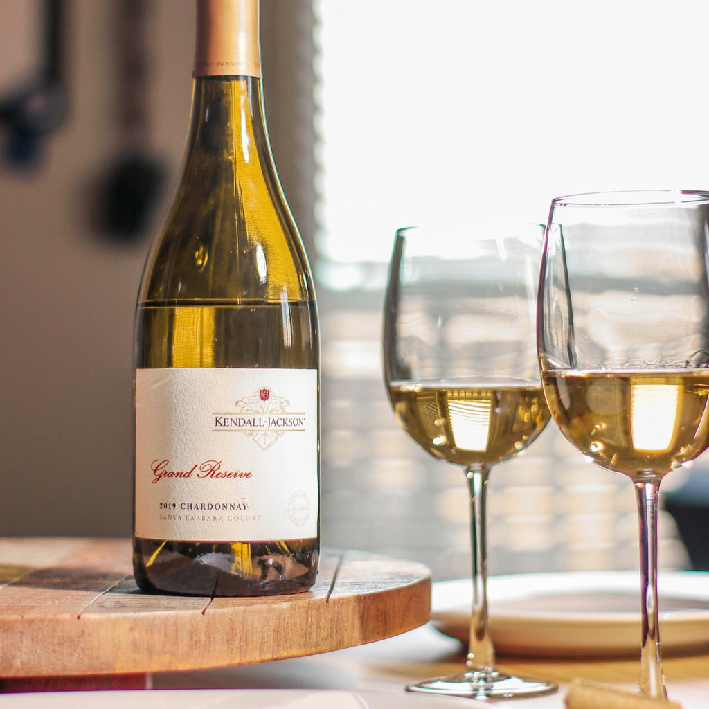 Kendall-Jackson Grand Reserve white wine bottle with two glasses on a table.