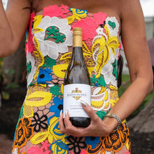 Load image into Gallery viewer, Woman holding a bottle of Kendall Jackson Chardonnay in a colourful dress.