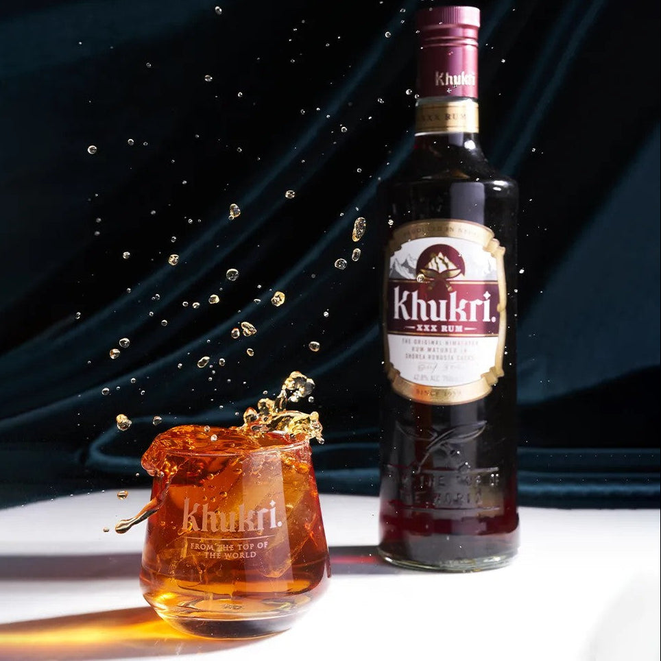 Load image into Gallery viewer, Khukri rum bottle and glass with a dark background