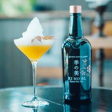 Load image into Gallery viewer, Bottle of Ki No Bi gin next to a cocktail with a blurred background