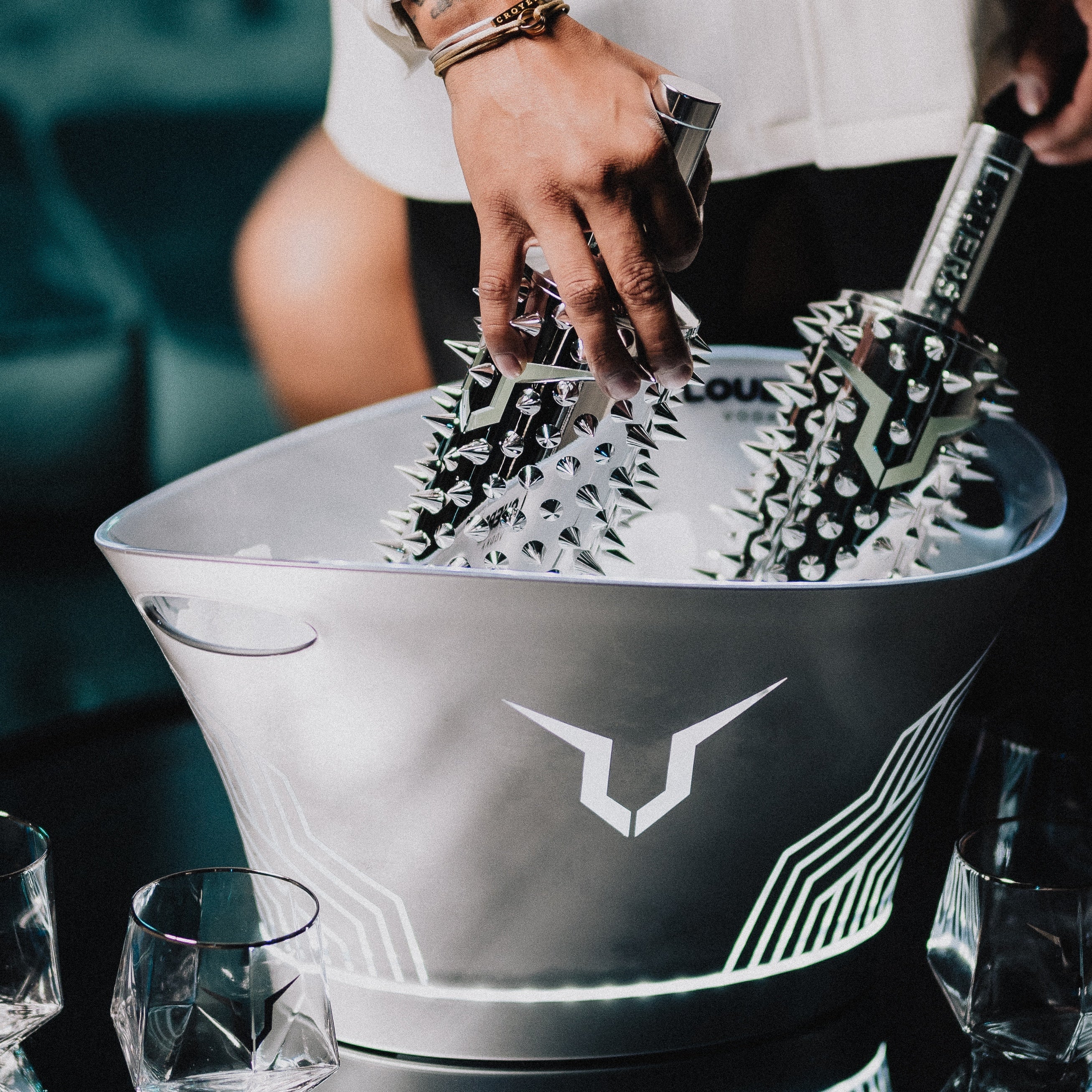 Load image into Gallery viewer, An image of two bottles of LOUERS vodka in an ice bucket in a bar setting with a man lifting them out.