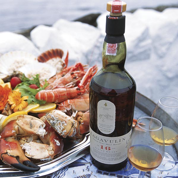 Load image into Gallery viewer, A bottle of Lagavulin 16 year old Single Malt Whisky together with a plate of crayfish