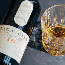 Load image into Gallery viewer, Lagavulin whisky bottle with a glass of whisky on a dark surface