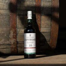 Load image into Gallery viewer, Bottle of Laphroaig 10 whisky against a wooden background
