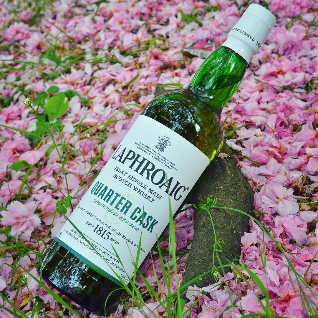 Load image into Gallery viewer, Laphroaig Quarter Cask whisky bottle on pink flower petals
