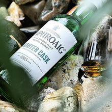 Load image into Gallery viewer, Laphroaig quarter cask whisky bottle and glass on a rocky surface