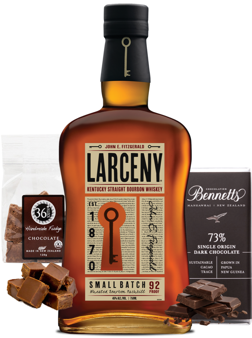 Load image into Gallery viewer, A bottle of Larceny Kentucky Straight Bourbon Whiskey centred on a white background, flanked by a bag of 36 Degrees Chocolate handmade fudge and a bar of Bennett's 73% Single Origin Dark Chocolate, with pieces of chocolate scattered in front.