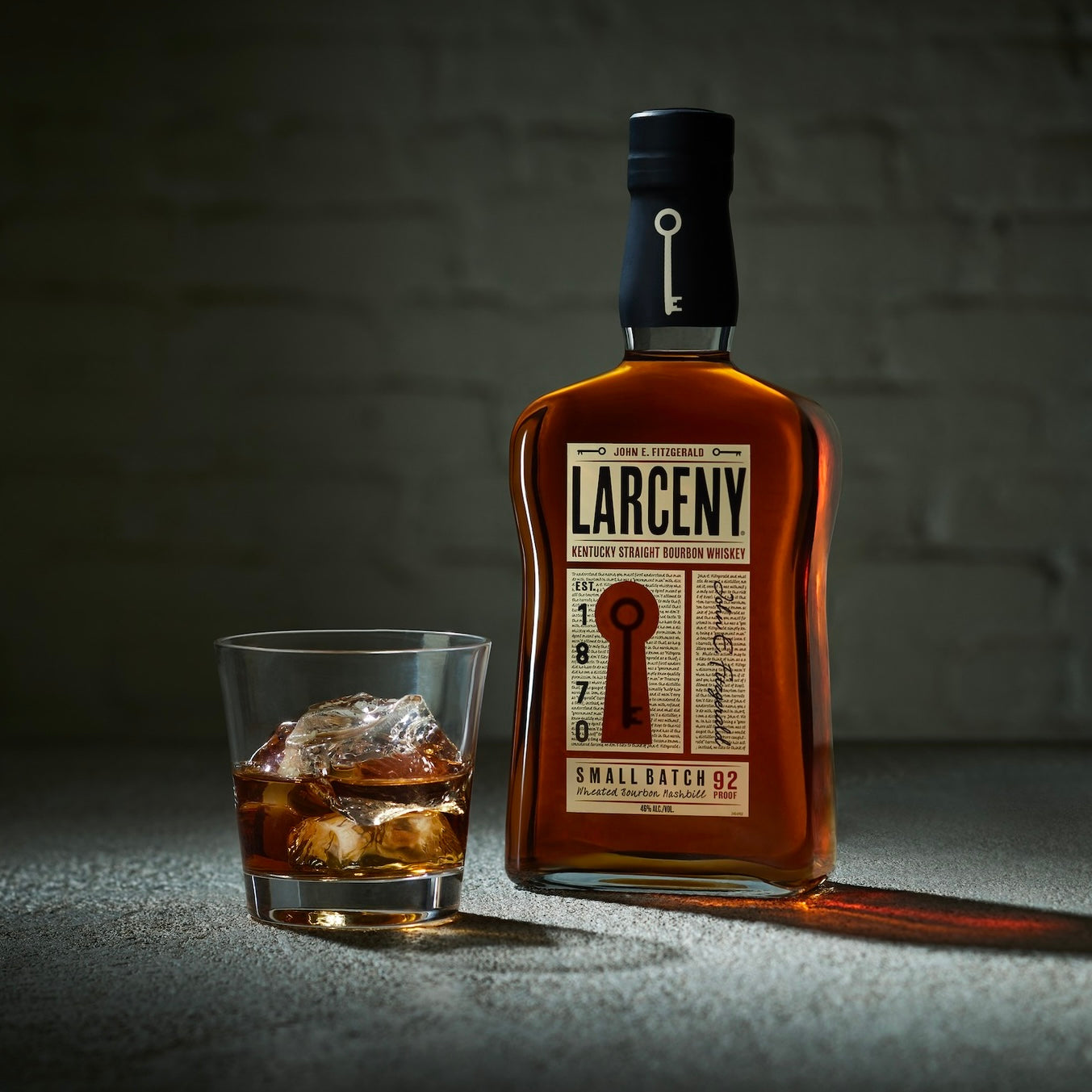 Load image into Gallery viewer, A bottle of Larceny Kentucky Straight Bourbon Whiskey  with a tumbler full of ice and whiskey
