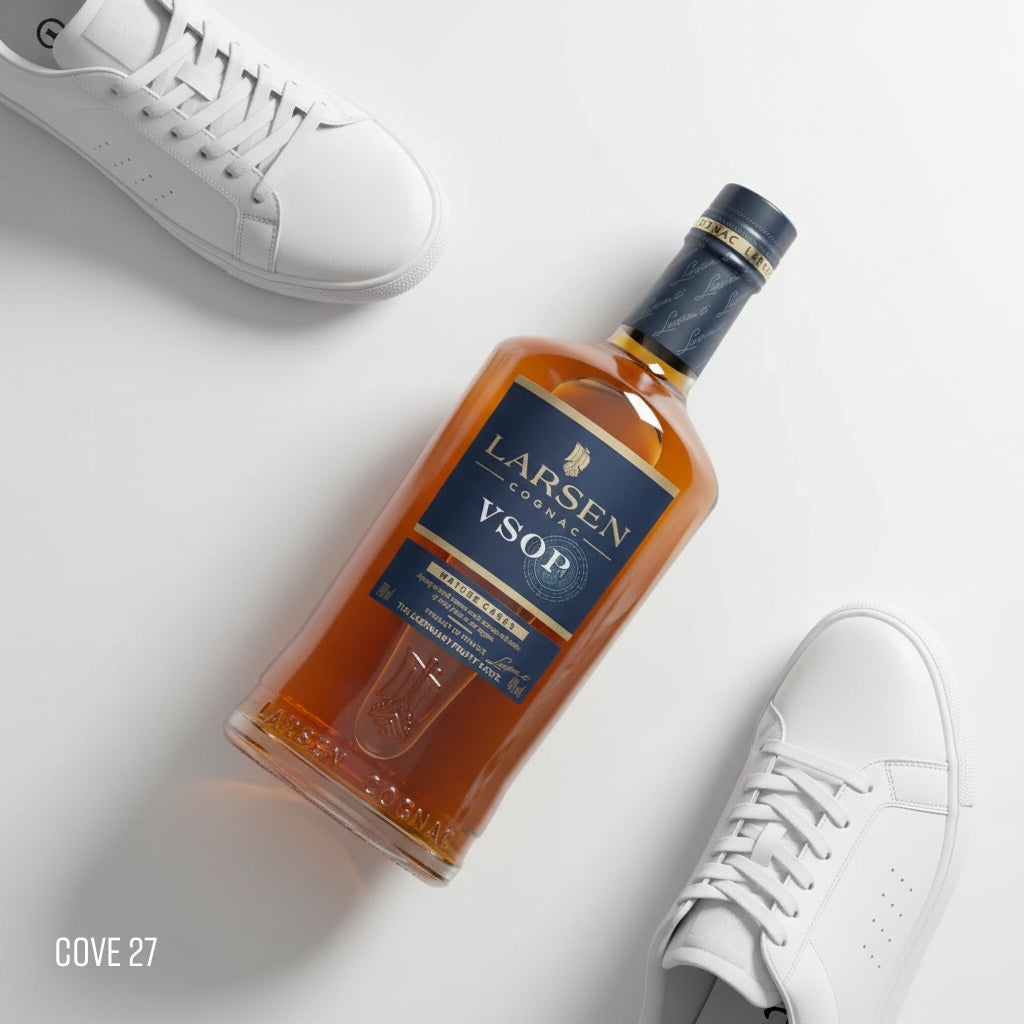 Load image into Gallery viewer, Bottle of Larsen VSOP cognac with white sneakers on a light gray background