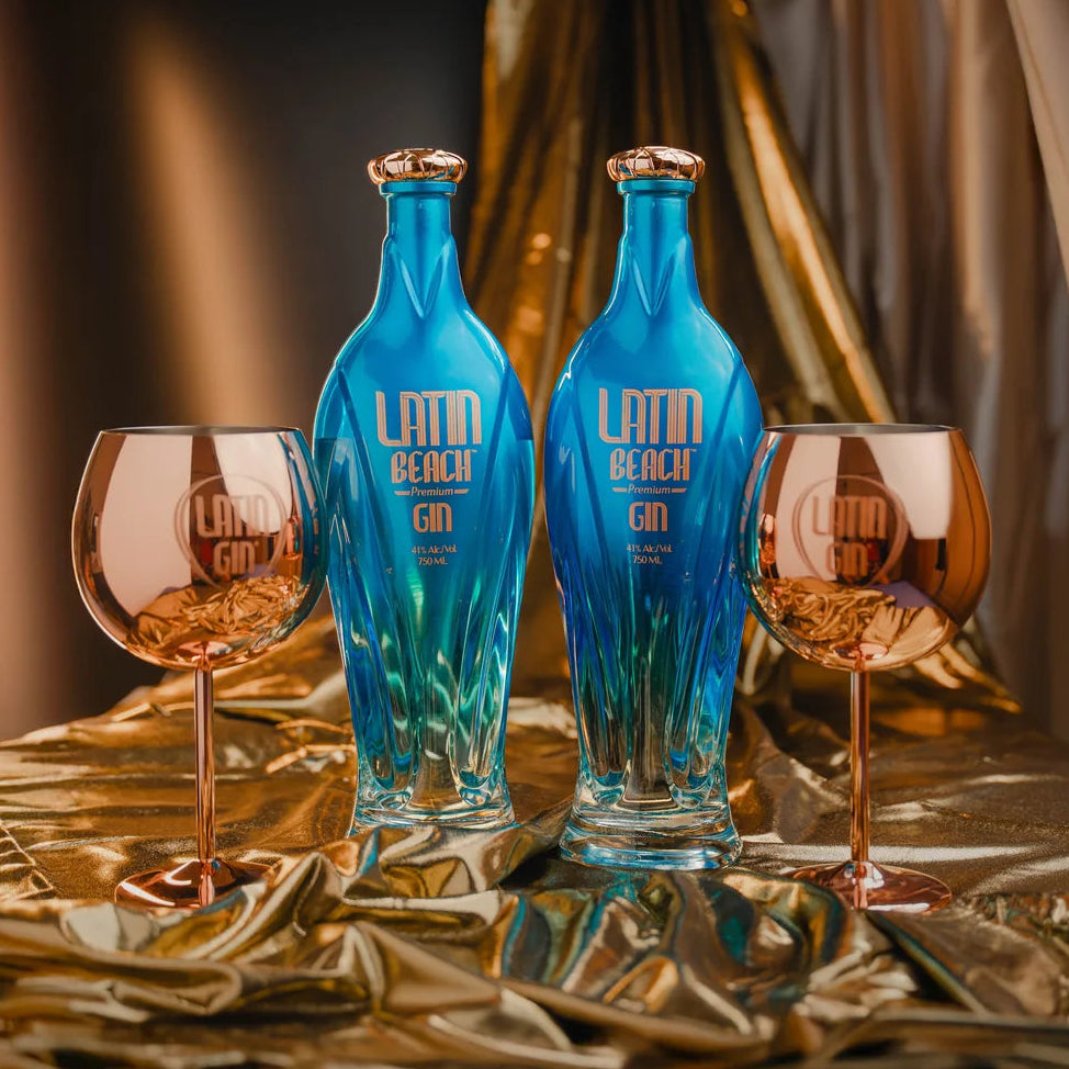 Load image into Gallery viewer, Two blue bottles of Latin Beach Gin with two glasses on a reflective surface.