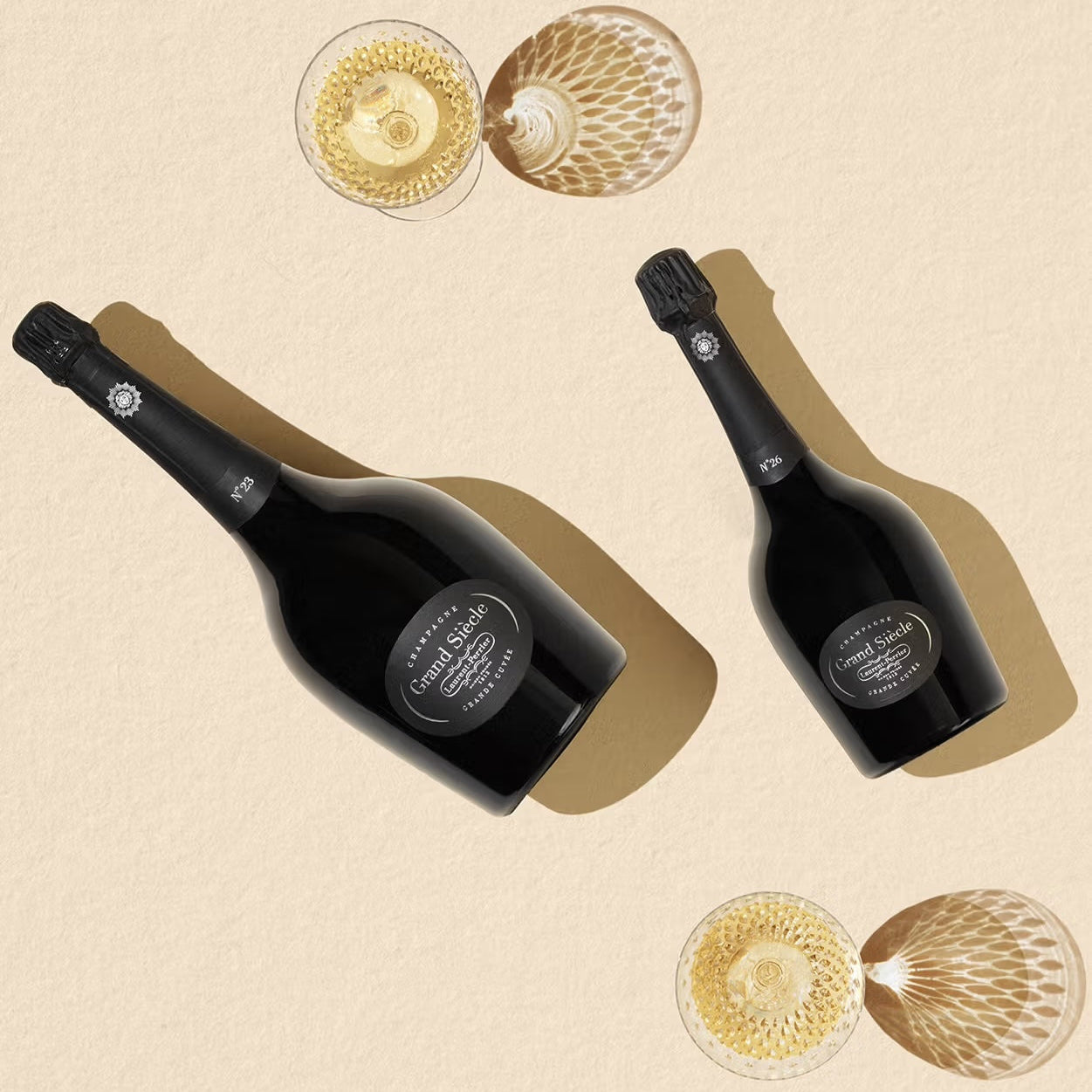 Load image into Gallery viewer, Two bottles of champagne with empty glasses on a beige background