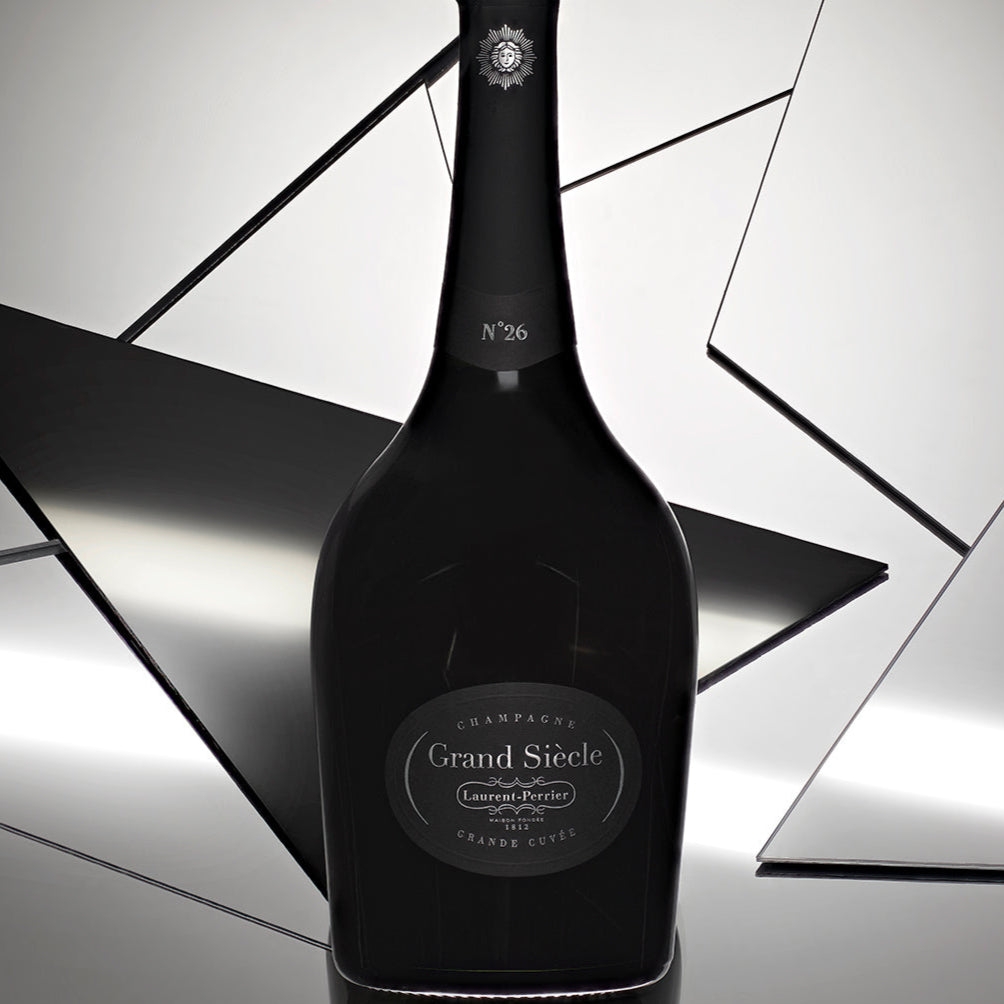 Black champagne bottle with 'Grand Siecle' label on a reflective surface