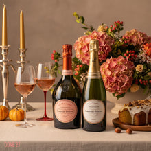 Load image into Gallery viewer, Two bottles of Laurent-Perrier champagne on a table with glasses, flowers, and a cake.