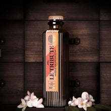 Load image into Gallery viewer, Bottle of Le Tribute Pink Grapefruit Tonic Water on a wooden background with flowers.