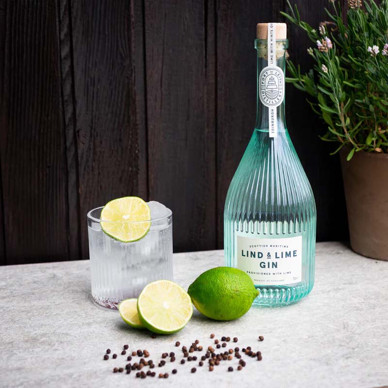 An image of a stunning and award-winning bottle of Lind & Lime London Dry Gin from Leith in Scotland, standing next to a delicious gin and tonic cocktail