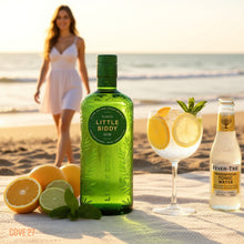 Load image into Gallery viewer, Green bottle of Little Biddy Gin with a glass of gin and tonic on a beach.