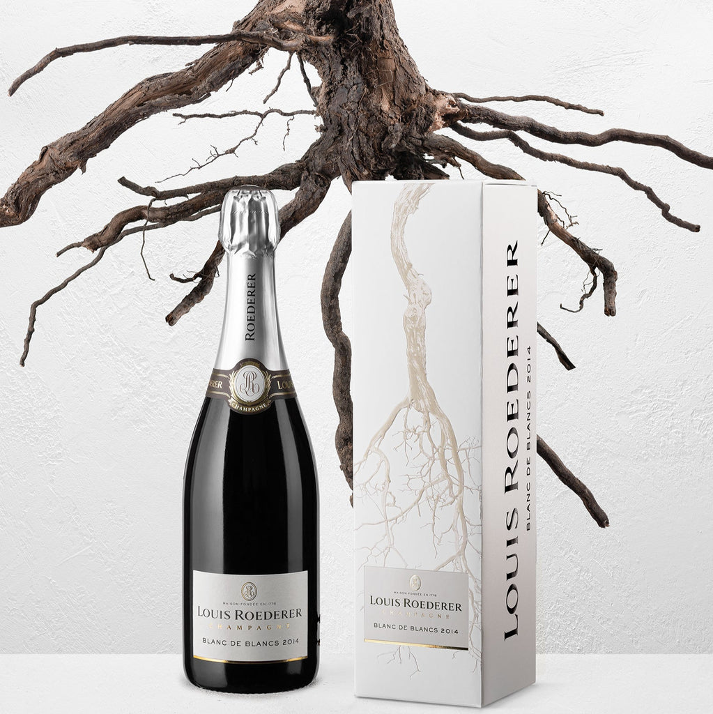 Louis Roederer champagne bottle and packaging with a white background and tree branches.
