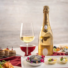 Load image into Gallery viewer, Bottle of Louis Roederer Cristal champagne with a glass on a table with appetizers