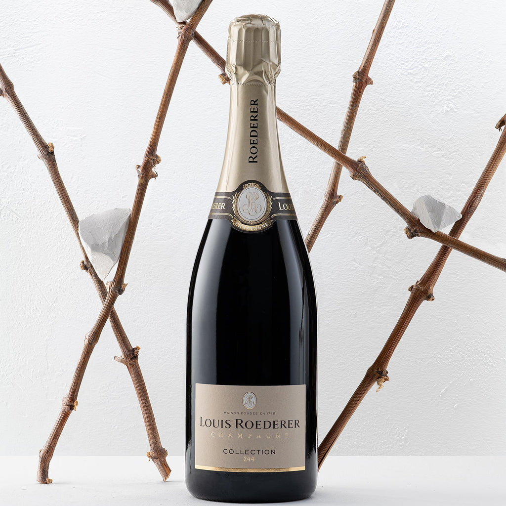 Louis Roederer champagne bottle with decorative branches in the background