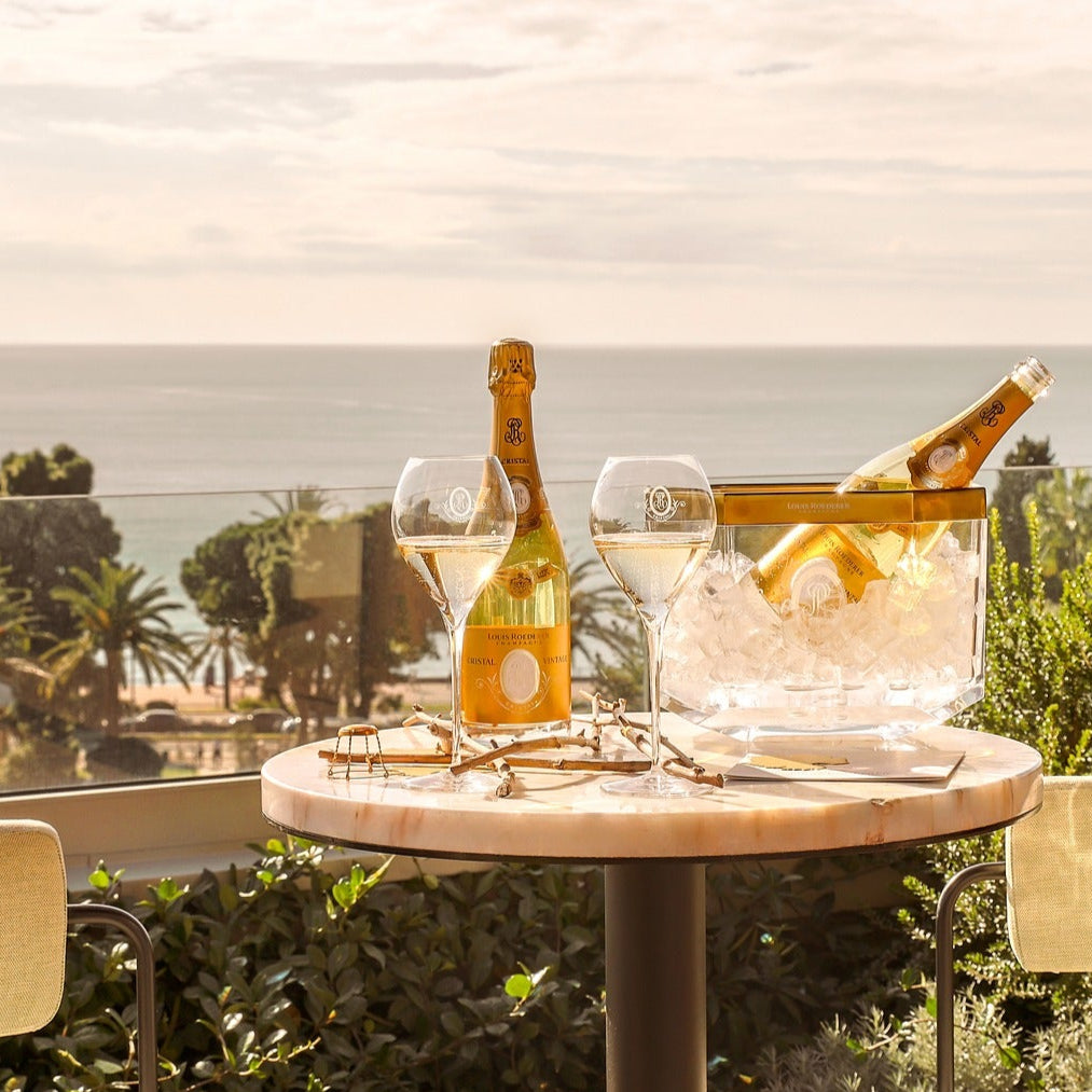 Table with champagne and glasses on a balcony with ocean view