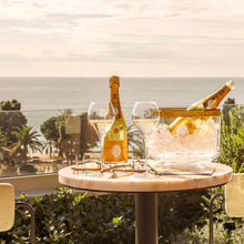 Load image into Gallery viewer, Table with champagne and glasses on a balcony with ocean view
