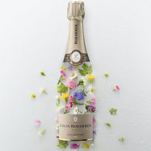 Load image into Gallery viewer, An empty bottle of Louis Roederer Collection Champagne on a white background with flowers
