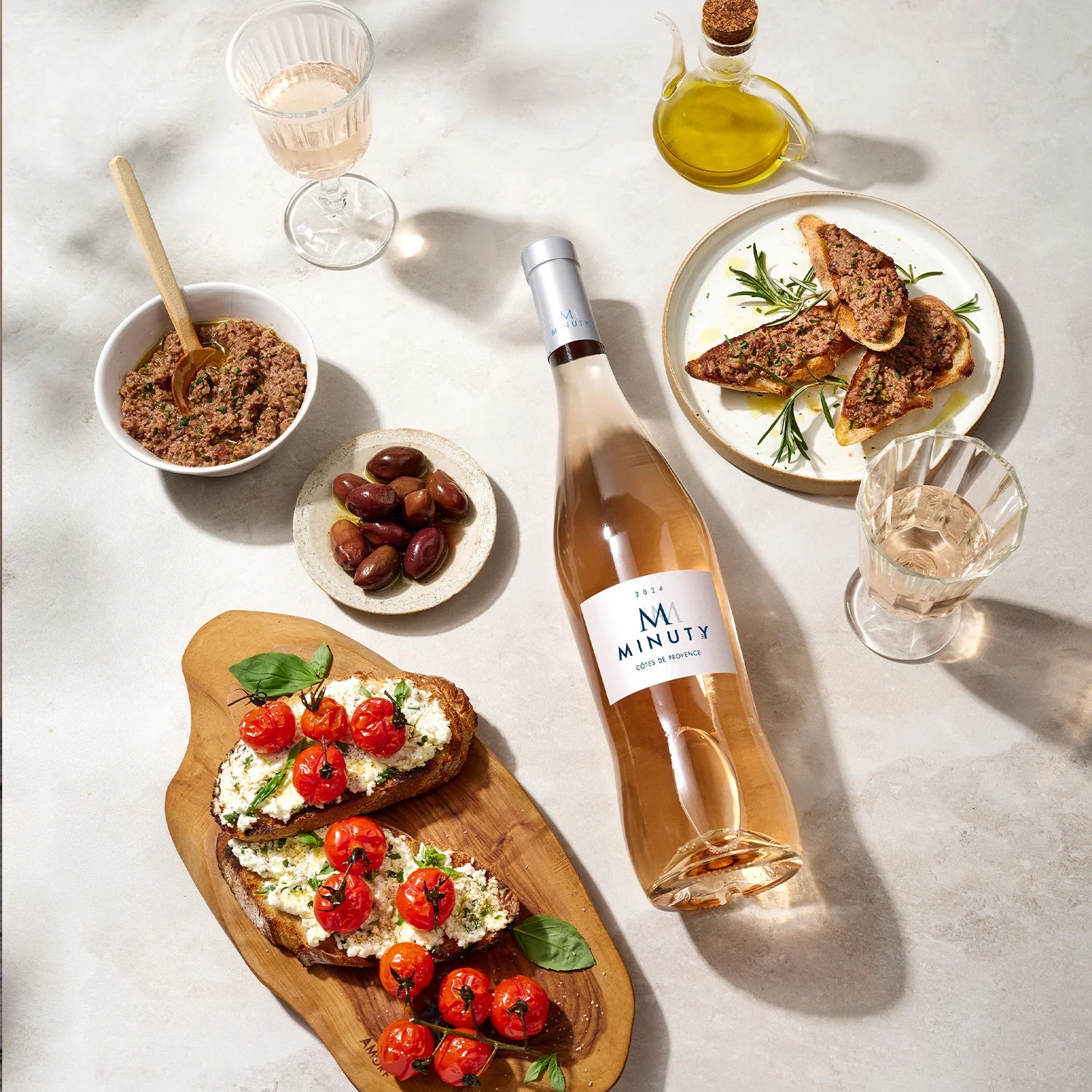 Load image into Gallery viewer, Bottle of M de Minuty rose wine with appetizers on a light surface