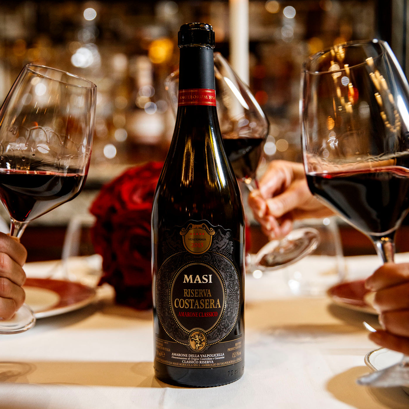 Load image into Gallery viewer, A bottle of MASI Amarone Riserva di Costasera Classico wine with three wine glasses next to it at a restaurant table setting