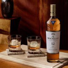 Load image into Gallery viewer, Macallan 12 year old whiskey bottle with two glasses on a wooden surface
