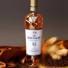 Load image into Gallery viewer, Bottle of The Macallan 12 YEAR OLD SHERRY CASK whisky with a wooden surface and food items in the background