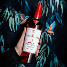Load image into Gallery viewer, Bottle of The Macallan 12 Year Old Single Malt Sherry Oak Cask Whisky held against a dark background with leaf patterns