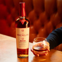Load image into Gallery viewer, The Macallan 12 Year Old Single Malt Sherry Oak Cask Whisky bottle and glass on a table with a blurred background