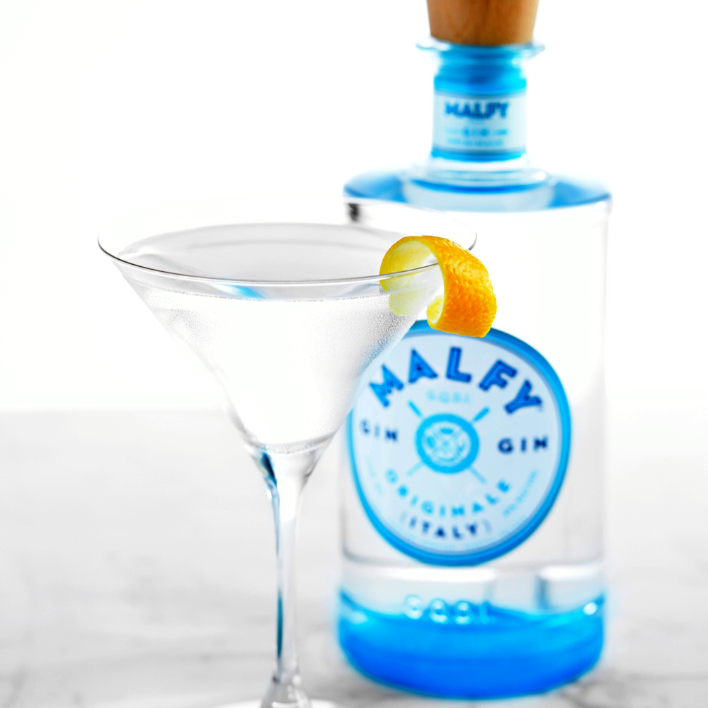 Load image into Gallery viewer, Bottle of Malfly gin with a martini glass and orange twist on a marble surface.