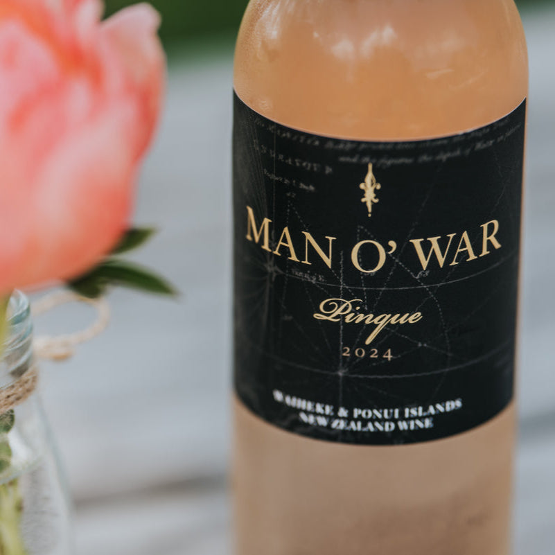 Load image into Gallery viewer, Bottle of Man O' War wine with a pink flower in the foreground