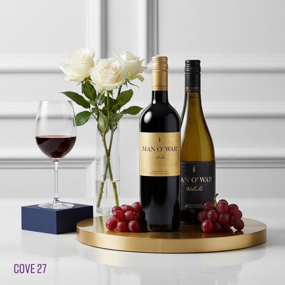 Load image into Gallery viewer, Two bottles of Man O' War wine on a gold tray with a glass of red wine, grapes, and white roses.