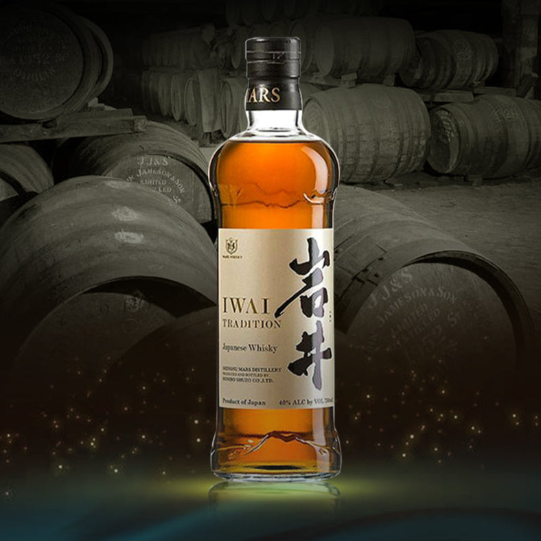 Bottle of Iwai Tradition Japanese whisky with barrels in the background.