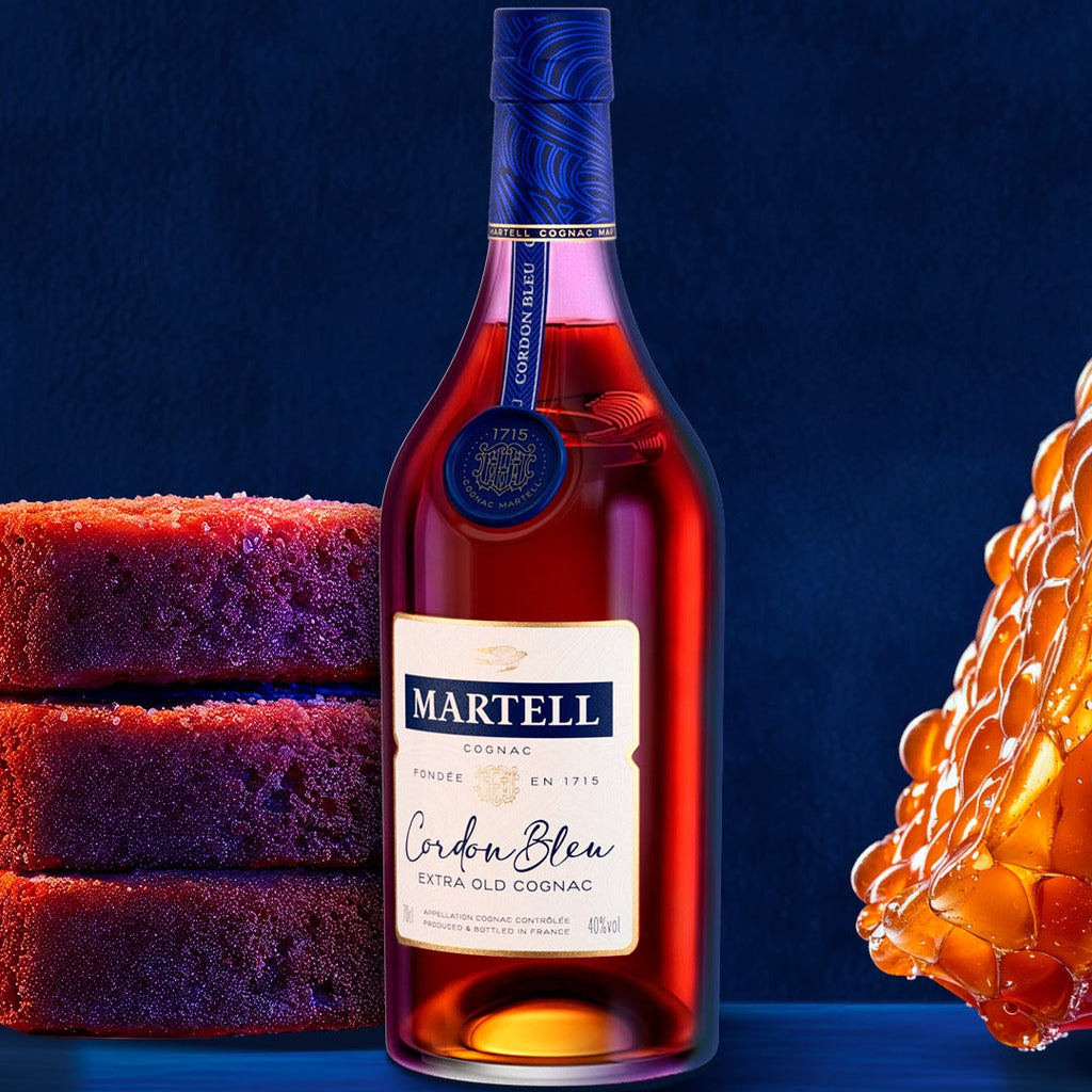 A bottle of Martell Cordon Bleu Cognac  with some cakes and honey on a blue background