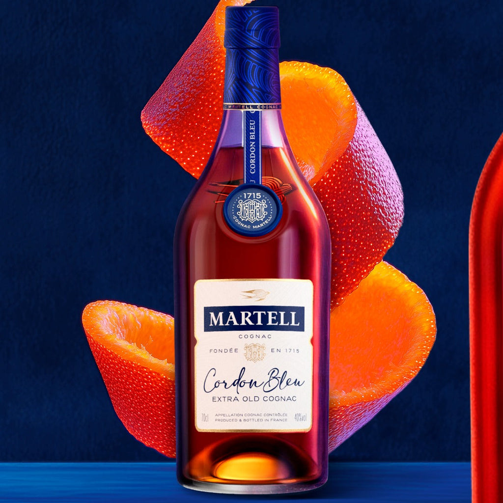 A bottle of Martell Cordon Bleu Cognac  with a large orange peel on a blue background