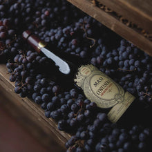 Load image into Gallery viewer, Bottle of Masi Costasera Amarone Classico wine surrounded by grapes on a wooden surface