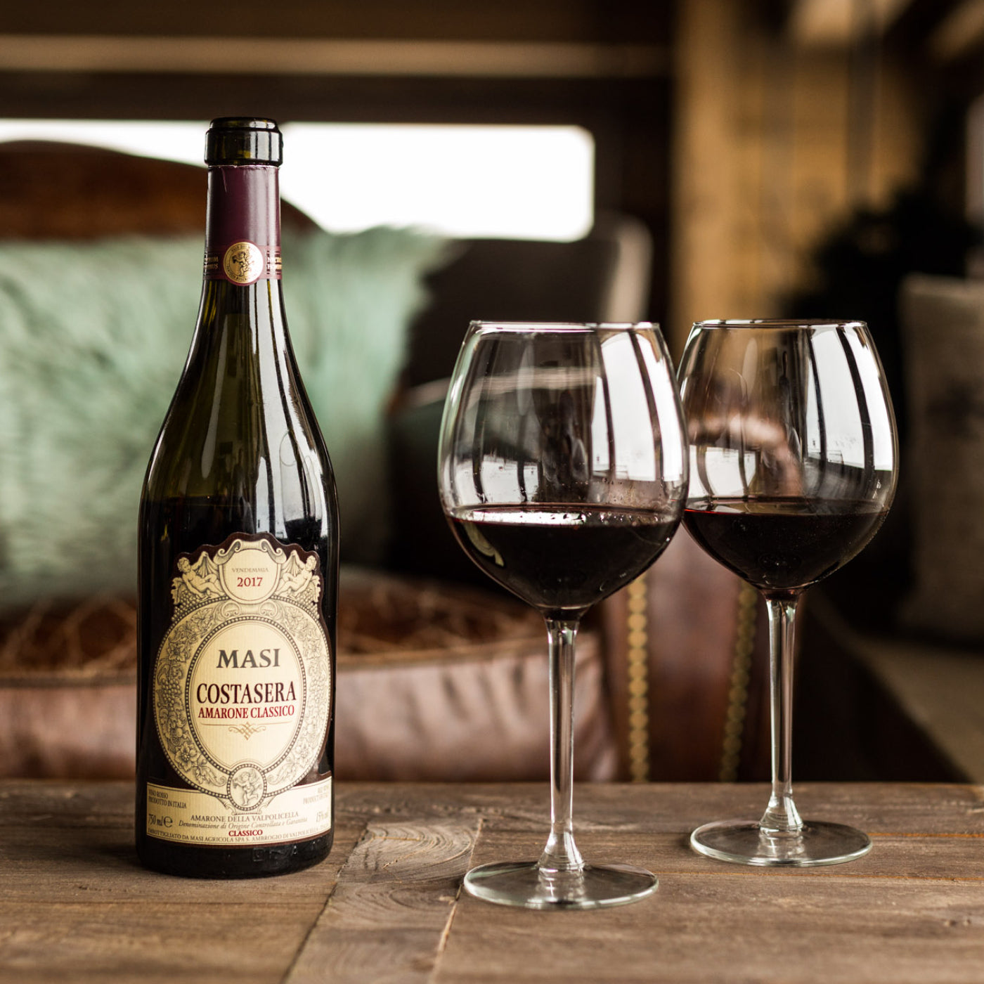 Load image into Gallery viewer, A bottle of Masi Costasera Amarone Classico red wine next to two wine glasses half full